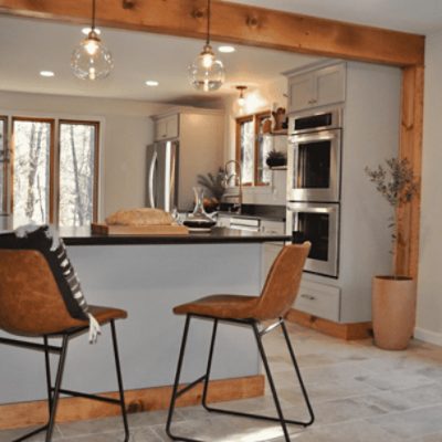 A kitchen with a bar top and wood trim with walls painted in natural choice sw 7011 by @kristenmcquaide.