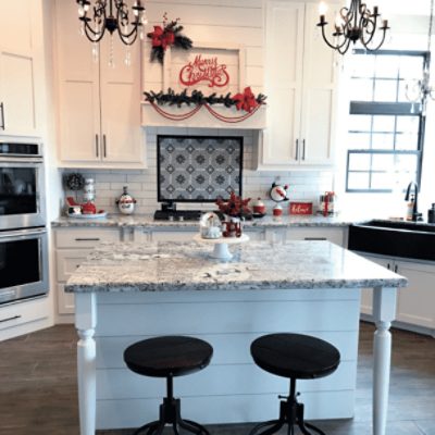 A large kitchen with an island and dual vertically stacked ovens painted in popular gray sw 6071 by @prairie_home_design.