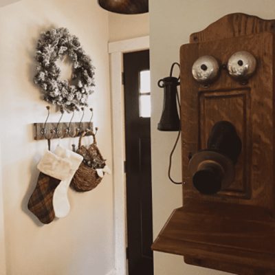 A foyer with an old fashioned telephone and walls painted in natural linen sw 9109 by @theoldhillhouse.