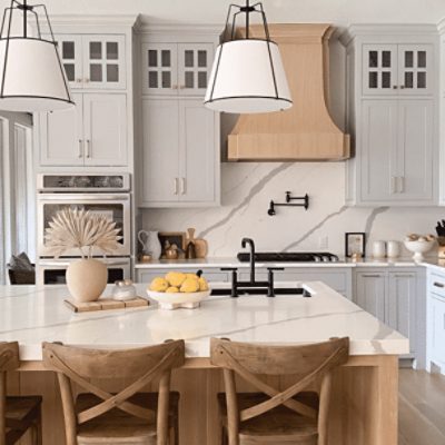 A kitchen with a large island painted in light french gray sw 0055 by @theredfernhome.