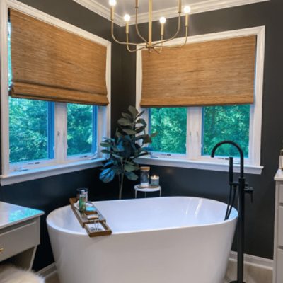 An elegant bathroom with a large tub with walls painted in iron ore sw 7069 by @willow_design_co.