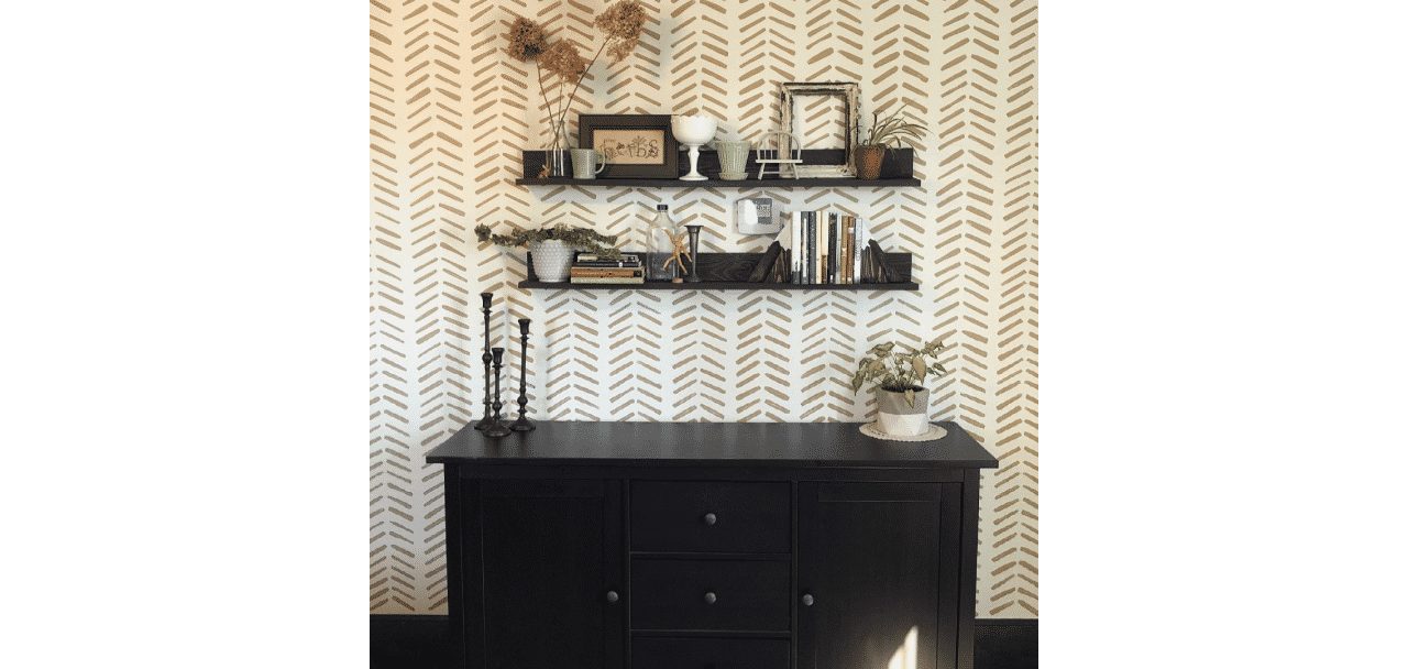 A patterned wall with 2 shelves and a dark wooden dresser in front. The walls are painted in origami white sw 7636 by @ylheidi.