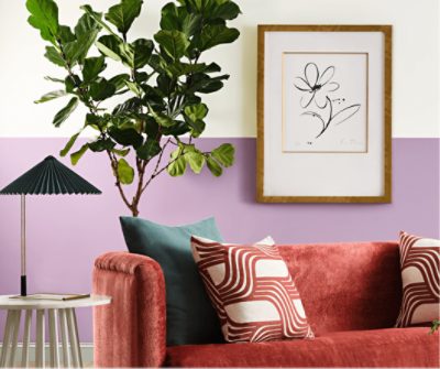 A rust colored sofa against a wall painted Radiant Lilac.