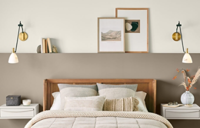 Neutral bedroom painted in Drift of Mist with two nightstands, lamps hung above them, and light decor.