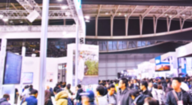 Blurry view of people navigating tradeshow for the latest EPS products and technologies