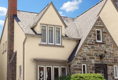 A traditional-style home with tan paint and a brick entryway. S-W Colors featured: SW 6141, SW 7514, SW 7083