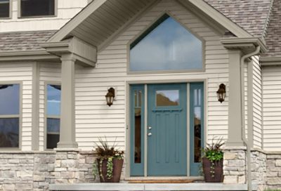 A white traditional home with gray trim and a decorative window at the entry. S-W colors featured: SW 6385, SW 7644, SW 7617.