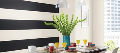 A dining room with a black and white striped wall 