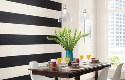 A dining room with a black and white striped wall.