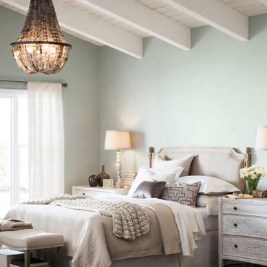 A subtle bedroom with blue walls and a white ceiling.