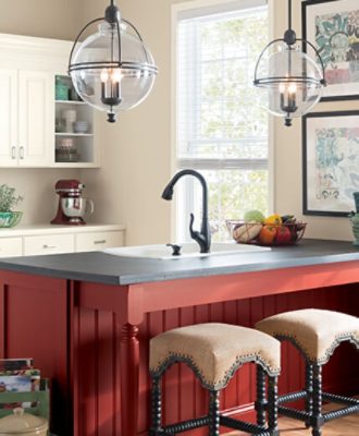 A bright kitchen with windows, island and two chandeliers