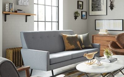 A contemporary living room with gray couch, which coffee table, and leather chair