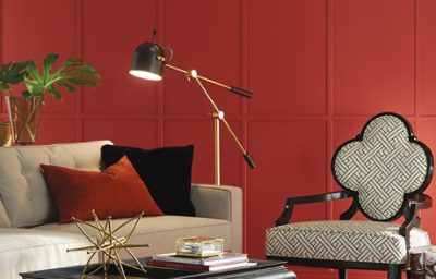 An orange modern day living room with orange walls and abstract furniture.