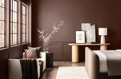Darker room with love seat, tables with decor.