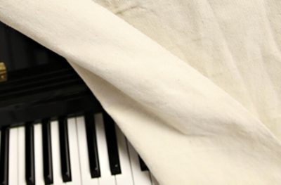 A piano covered with a painter's tarp.