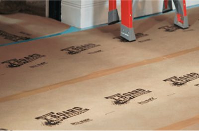 Trimaco surface protector on a floor with a red ladder leaning against a wall.