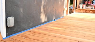 An unfinished outdoor deck with masked tape.