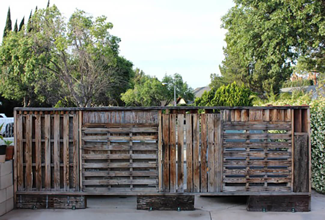 A dark, unstained outdoor pallet wall