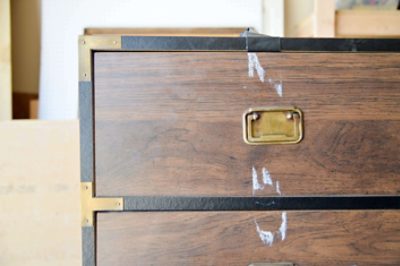 An outdated laminate dresser with tape residue.