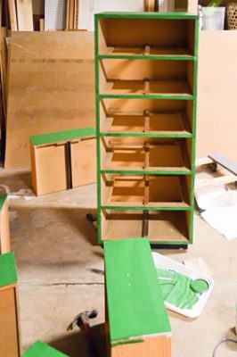 A laminate dresser being painted green.