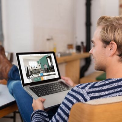 A person holding a laptop and using the Sherwin-Williams Color Visualizer.