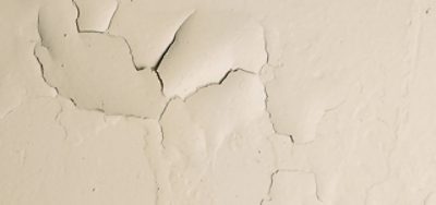 A close-up of paint peeling off a wall due to moisture.