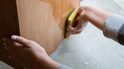 A woman washing a wooden dresser