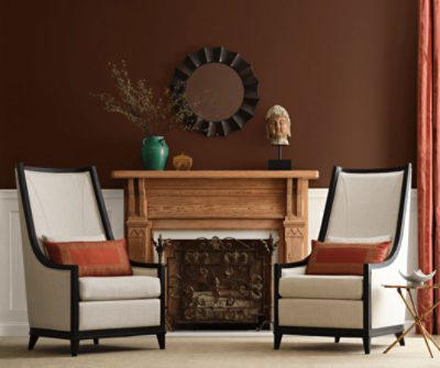 Two chairs in front of a fireplace with walls painted French Roast SW6069 on the upper portion and the board and batten painted Oyster White SW7637.