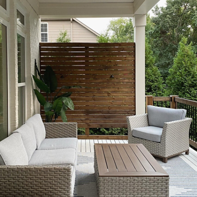 A white porch with neutral furniture.
