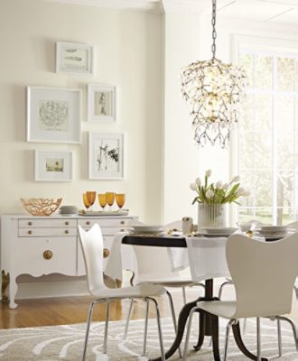 An intimate dining room with round table, flower centerpiece, and rustic side table.