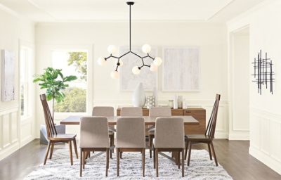 A contemporary dining room with large table, stylish lights, and white walls.