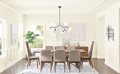A contemporary dining room with large table, stylish lights, and white walls