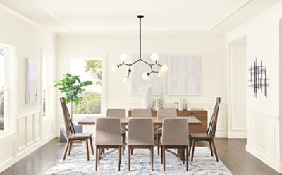 A contemporary dining room with large table, stylish lights, and white walls