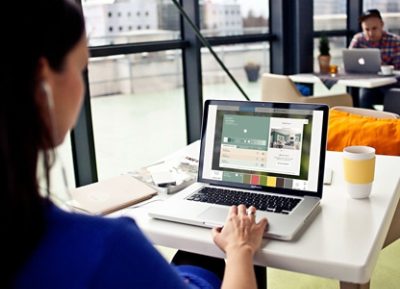 A person in a coffee shop using the Color Visualizer tool on their laptop.