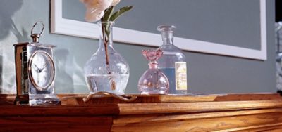 A buffet table with a clock and spirits sitting on top.