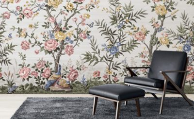 Elegant sitting area featuring a cream upholstered armchair and dark wood console table against a dramatic black wallpaper mural with flowing metallic botanical motifs.