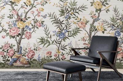 Elegant sitting area featuring a cream upholstered armchair and dark wood console table against a dramatic black wallpaper mural with flowing metallic botanical motifs.