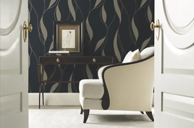 Contemporary living space featuring a colorful chinoiserie-style wallpaper with flowering trees, birds, and butterflies, paired with a black lounge chair and ottoman.