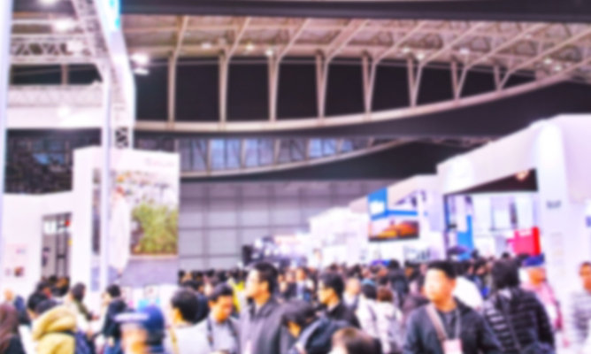Blurry view of people navigating tradeshow for the latest EPS products and technologies
