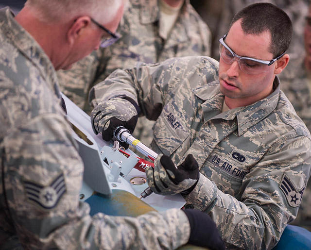 Airmen installing parts to munitions